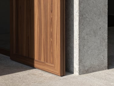 Close-up detail shot of a custom walnut millwork partition meeting a raw historic concrete column. Sharp directional daylight casts clean shadows across the wood grain and textured stone floor.