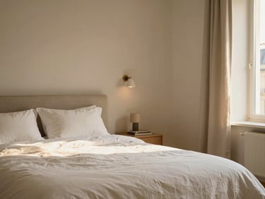 Warm editorial interior photography of a refined Parisian apartment bedroom, crisp white linen, soft golden-hour light, minimalist decor, 35mm.