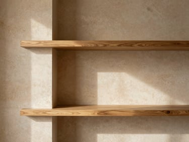 Minimalist residential interior with warm sandstone walls, custom oak shelving, natural side-lighting casting soft shadows
