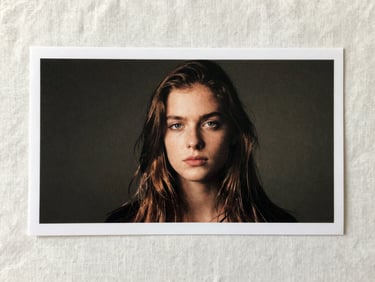 Finished printed piece photographed flat on a pale linen surface under diffused studio light, full bleed visible, clean margins, no hands or props — artifact only