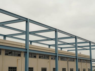 Environmental shot of a mid-market industrial facility exterior under an overcast sky, architectural steel frames, realistic documentary style.