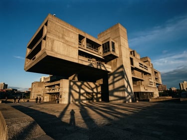 Dramatic wide-angle architectural photograph of a sharp concrete cantilever building, late-afternoon sun casting long geometric shadows, 35mm film.