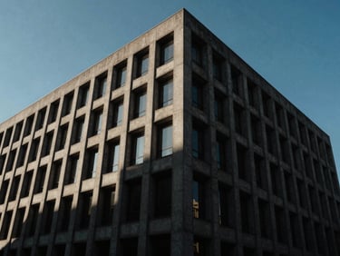 Low-angle exterior shot of a modern brutalist concrete corporate headquarters building, sharp geometric lines, late-afternoon sun casting deep shadows, architectural editorial style