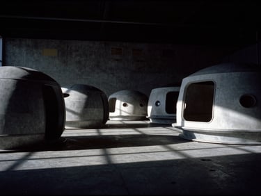 Minimalist technical lab interior with structural prototype models of future space habitats, deep shadows, 35mm film style