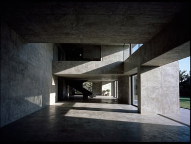 High-contrast architectural photograph of a modern luxury villa interior with sharp shadows, concrete walls, wide-angle lens, 35mm film style
