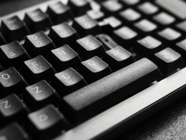 Macro close-up of a sleek mechanical keyboard and metallic desk surface, high-contrast studio lighting, deep shadows, sharp focus, 35mm film grain.