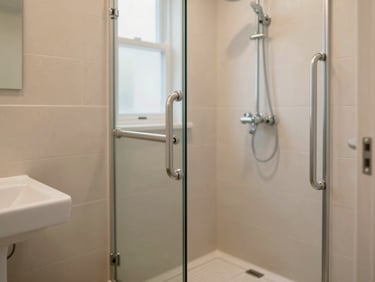 Clean, modern accessible bathroom in a residential care home with safety grab bars and a zero-threshold shower.