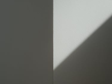 Close-up macro shot of a perfectly smooth, white drywall corner, crisp geometric shadow lines, flawless Q4 surface finish under sharp side lighting.