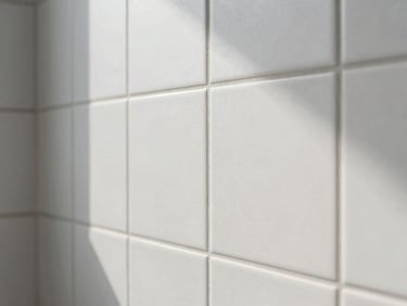 Close-up macro of perfect tile alignment in a modern bathroom, clean grey joints, bright natural daylight, crisp focus.