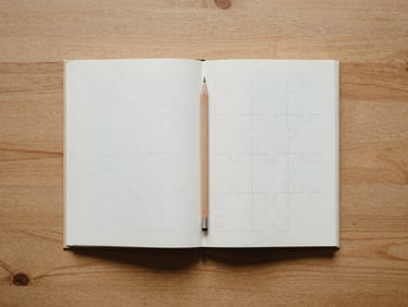 Overhead flat-lay of an open puzzle book on a clean wooden table, a sharp pencil resting on the page, soft morning light