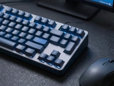 Macro close-up of a mechanical keyboard and a mouse on a dark slate desk, subtle blue screen glow, sharp focus