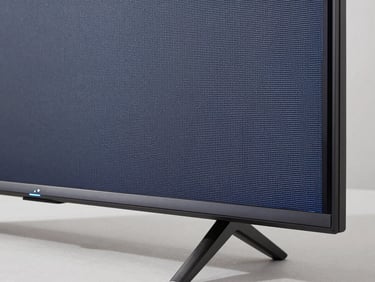 Macro shot of a sleek television frame showing crisp pixel density, bright natural daylight, neutral background