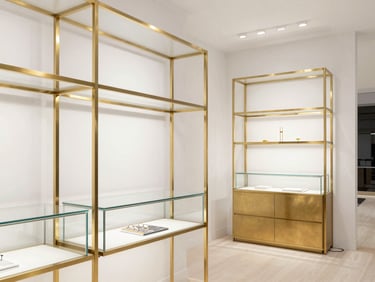 High-end specialty boutique interior with custom brass fixtures and geometric glass display cases, sharp architectural focus