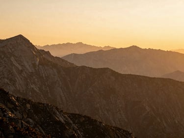 High-altitude mountain range at sunset, warm tones, majestic and serene, medium format film