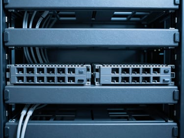 Symmetrical macro shot of clean server rack cabling, cool clinical daylight, sharp defined shadows, blueprint blue and slate gray tones.