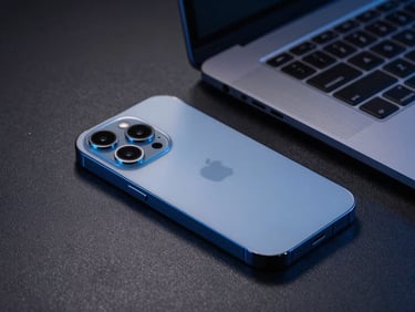 Close-up of a premium smartphone and sleek laptop on a textured charcoal desk, dramatic blue side lighting