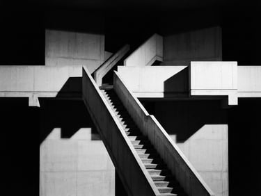 Minimalist black and white architectural photography, stark high-contrast studio lighting, clean geometric concrete structures with sharp shadows, 35mm lens, centered composition