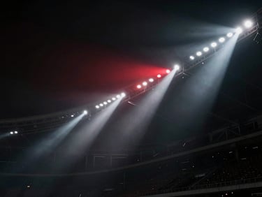 Low-angle shot of powerful stadium lights piercing through night fog, high contrast, dark atmosphere