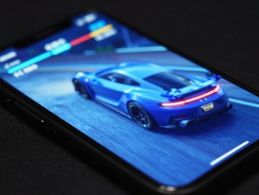 Close-up of a mobile device screen displaying a high-fidelity racing game interface, glowing electric blue, in a dark setting, sleek tech photography, sharp focus.