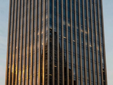 Editorial architectural photography of a modern corporate skyscraper facade in Mexico City, golden hour light, glass and steel architecture, sharp focus, 35mm, straight vertical lines.
