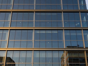 Modern corporate building facade with glass panels reflecting the blue hour sky, clean lines, commercial real estate
