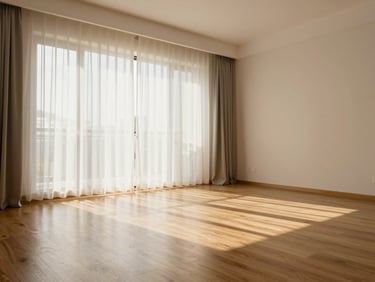 Wide environmental shot of a tidy residential living room after cleaning, warm afternoon light through sheer curtains, wood floors visible, no people