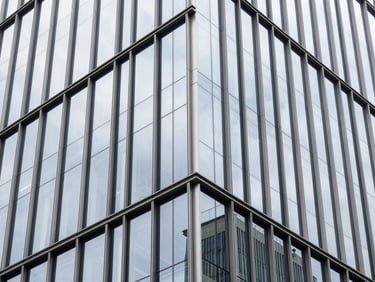 Abstract geometric pattern of modern office skyscraper glass and steel facade reflecting bright overcast daylight