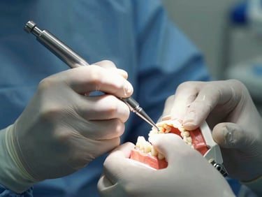 Close-up macro photograph of a dentist in sterile surgical attire performing a precise procedure on a dental model under cool clinical lighting.