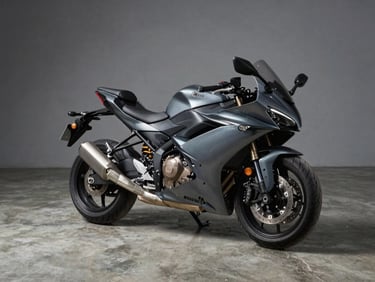 Wide studio frame of a sport-touring motorcycle in gunmetal grey, hard directional strobe from upper-left casting clean shadow, shot from 3/4 front angle on polished concrete