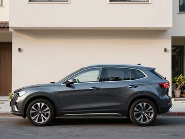 Clean eye-level profile of a dark grey compact SUV parked on a quiet residential street, soft morning light