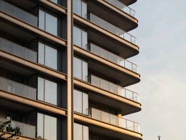 Architectural close-up of Prestige luxury development exterior, modern glass facade, golden hour light