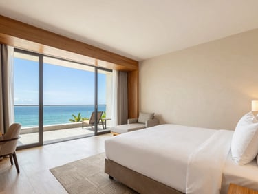 Bright modern deluxe suite hotel room with king bed, warm wood accents, soft daylight, clean design.