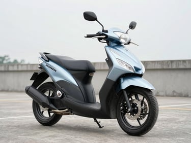 Close three-quarter front view of a Honda Beat or Yamaha Mio motorcycle on clean concrete under bright overcast daylight, showing full body condition, realistic silver-blue color, no glare