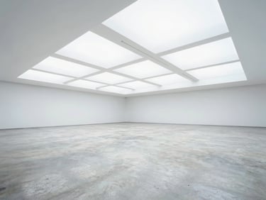 A spacious, empty modern event hall with polished concrete floors, high ceilings, bright airy lighting