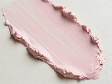 Texture swatch of a pink clay mask being swirled, soft focus, bright morning light, 35mm