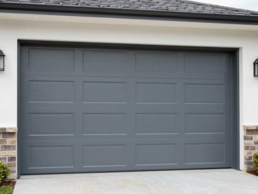 Medium shot of a newly installed modern steel garage door on a residential home, crisp daylight, sharp focus.