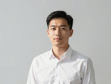 Professional corporate headshot of a male financial analyst, bright natural daylight, clean gray background
