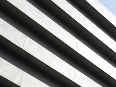 Architectural detail of a modern building's structural beams, high-contrast, sharp shadows, minimalist, 35mm lens.