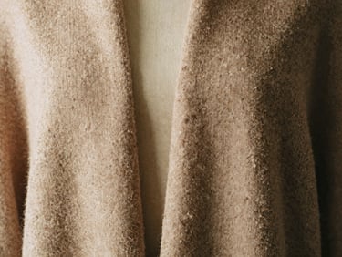 Close-up of double-faced cashmere draped over a female mannequin, soft light, rich nude tone, tactile fabric texture, 35mm film.