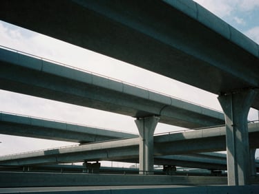 Abstract modern highway infrastructure with high-contrast architectural shadows, cool overcast daylight, 35mm