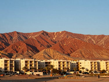 bright editorial travel photography, warm golden-hour sunlight, rich natural colors, high contrast, 35mm lens, Red Sea resort in El Sokhna with red mountains in background, bright daylight