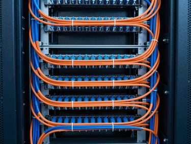 Symmetrical straight-on architectural shot of a pristine server rack with perfectly combed and color-coded blue and orange cables, high-contrast architectural lighting, 35mm