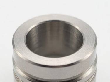 Macro photography of a custom-engineered small forged component, bright clean studio lighting, metallic steel tones.