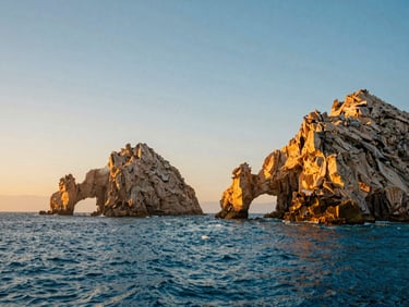 Cinematic landscape of the famous Land's End arch in Los Cabos at sunset, golden-hour natural light, deep blue sea, 35mm look