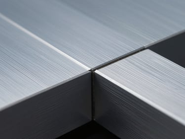 Extreme macro detail shot of a CNC-routed aluminum panel join, showing precision edge finish and exact color fidelity under cool studio light.