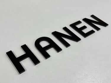 A precision CNC laser cutting machine carving an intricate geometric pattern into a light wood panel with sparks.