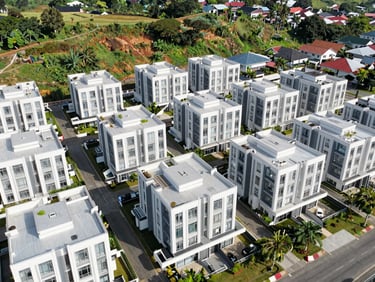 Drone perspective of a residential cluster nestled in green hills, bright daylight, Sentul.