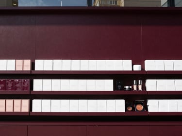crisp corporate photography, wide angle, 35mm, clear natural daylight, rich deep tones, high contrast, clean modern retail display featuring boxed cosmetic products