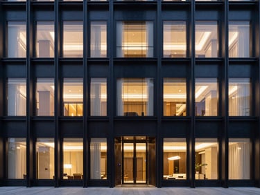 Sleek architectural details of a luxury hotel facade at twilight, warm interior lights reflecting on dark steel.
