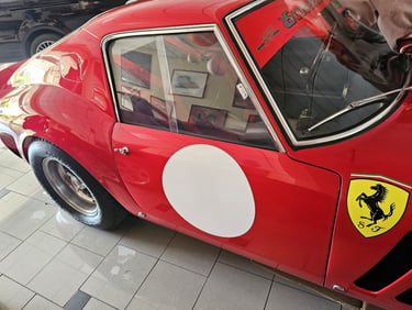 Classic red Ferrari 250 GTO vintage race car with a white roundel and Prancing Horse logo.